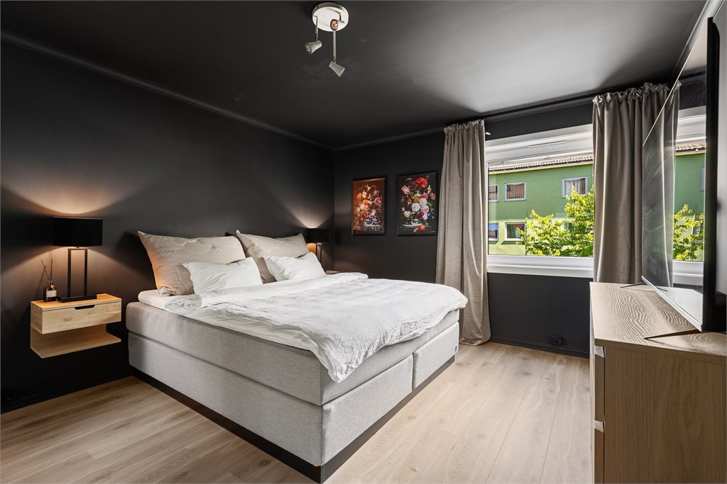Romslig og lunt hovedsoverom med stor skyvedørsgarderobe